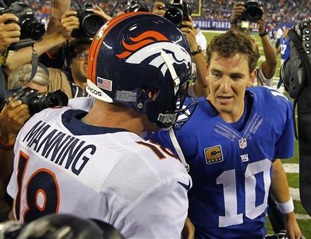 Broncos' Peyton Manning talks with his brother, Giants' Eli Manning after the Broncos defeated the Giants in their NFL football game in East Rutherford